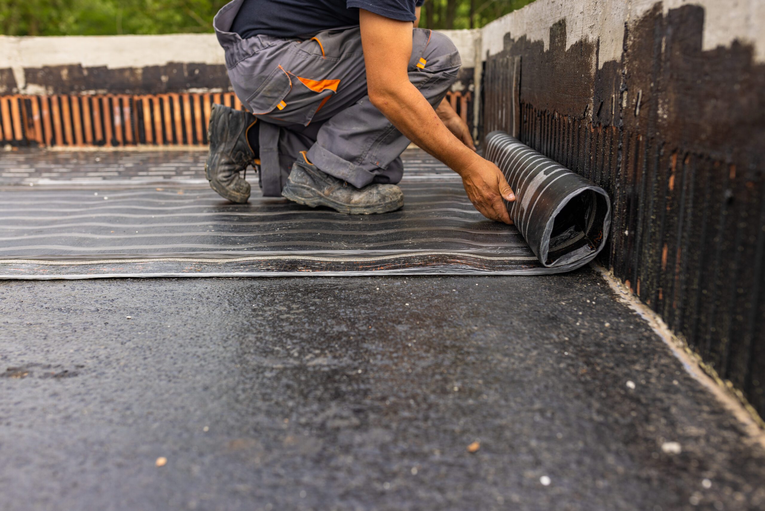 Worker laying the vapor barrier for the roof